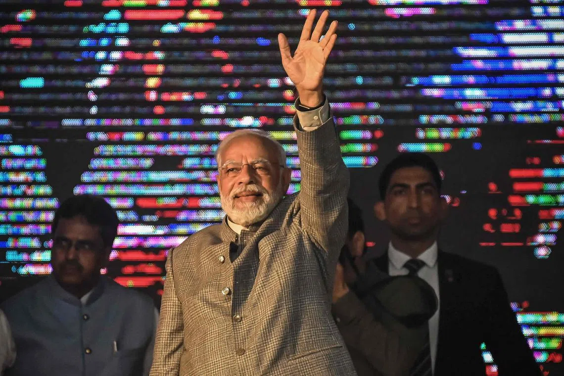 India's prime minister Narendra Modi waves to the supporters as he arrives to attend a  public rally held at Swami Vivekananda Stadium in Agartala on December 18, 2022. (Photo by Abhisek SAHA / AFP)