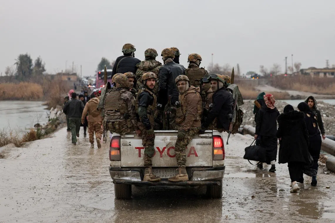 FILE PHOTO: Military personnel in a vehicle at the crossing connecting the two banks of the Euphrates River, as they attempt to cross to the other side after the Syrian Democratic Forces (SDF) withdrew from Deir al-Zor province and the Syrian army took full control over the area, in Deir al-Zor, Syria, January 18, 2026. REUTERS/Khalil Ashawi/File Photo