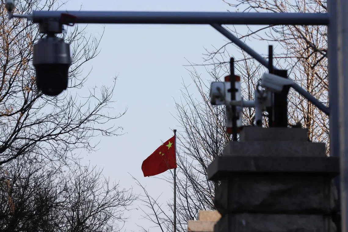 FILE PHOTO: A Chinese flag is seen near surveillance cameras outside the Beijing No. 2 Intermediate People's Court, where Australian journalist Cheng Lei is expected to face trial on state secrets charges, in Beijing, China March 31, 2022. REUTERS/Florence Lo/File Photo