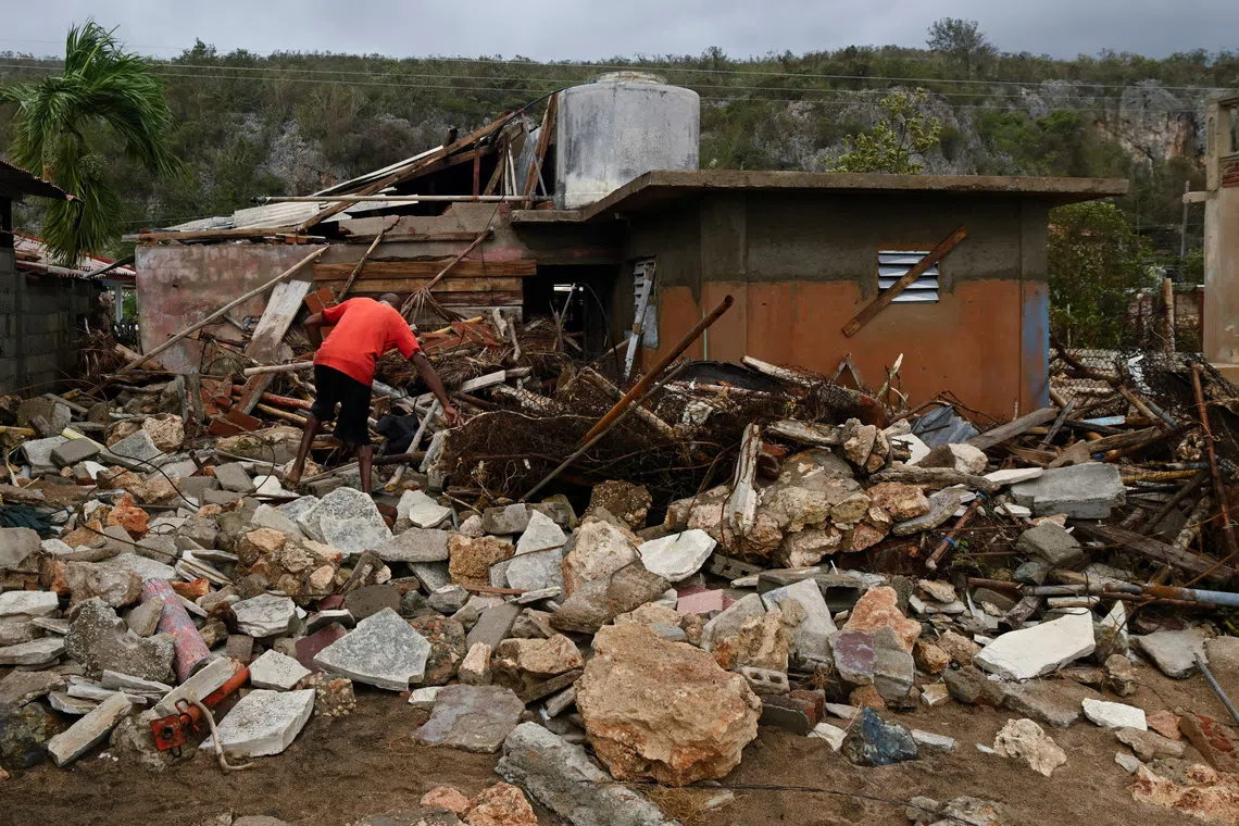 A resident removes debris outside his house in the aftermath of Hurricane Melissa, in Santiago, Cuba, October 29, 2025. REUTERS/Norlys Perez