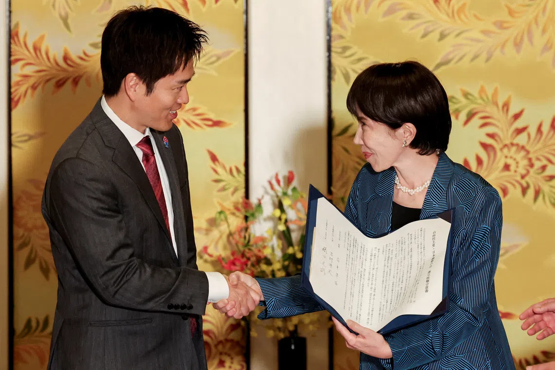 Leader of Japan's ruling Liberal Democratic Party (LDP) Sanae Takaichi shakes hands with Japan Innovation Party's, known as Ishin, leader Hirofumi Yoshimura after signing a document on the coalition deal, at Japan's National Diet Building in Tokyo, Japan, October 20, 2025. REUTERS/Kim Kyung-Hoon      TPX IMAGES OF THE DAY