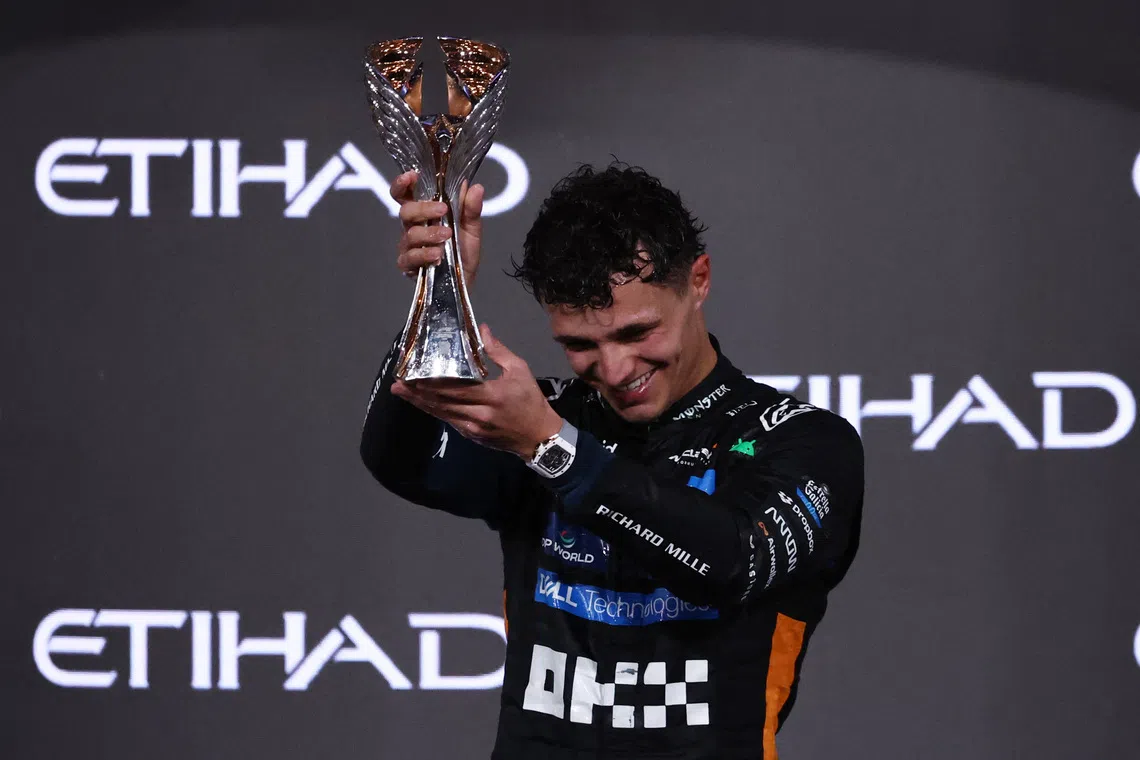 Formula One F1 - Abu Dhabi Grand Prix - Yas Marina Circuit, Abu Dhabi, United Arab Emirates - December 7, 2025 McLaren's Lando Norris celebrates on the podium with the trophy after becoming the 2025 Formula One World Champion REUTERS/Amr Alfiky