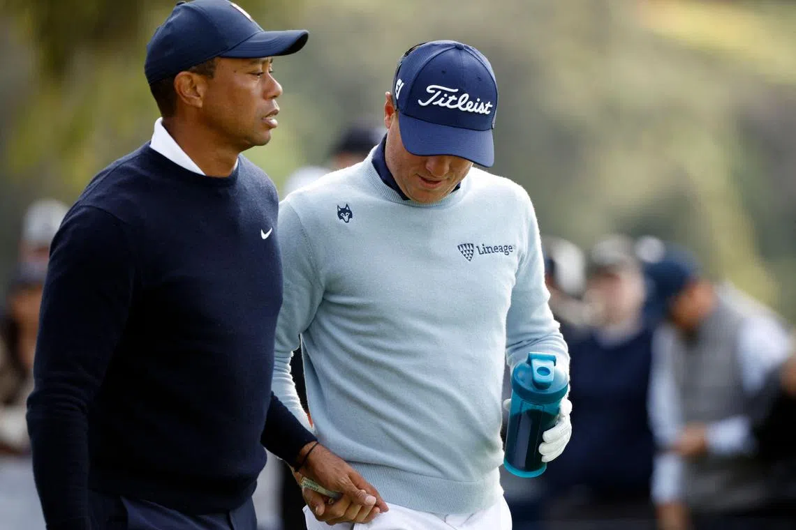 Tiger Woods (left) handing a tampon to flight-mate Justin Thomas during the first round of The Genesis Invitational on Thursday. 