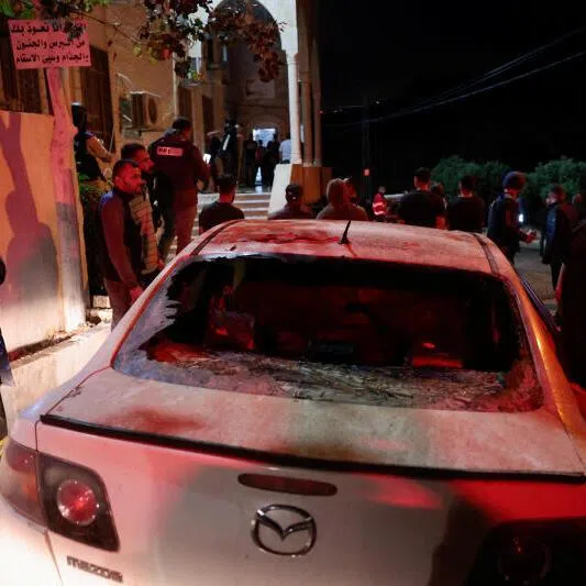 Palestinians gather near a damaged car, which Palestinians say was attacked by settlers, on June 14 in Burqa, near Ramallah, in the Israeli-occupied West Bank.