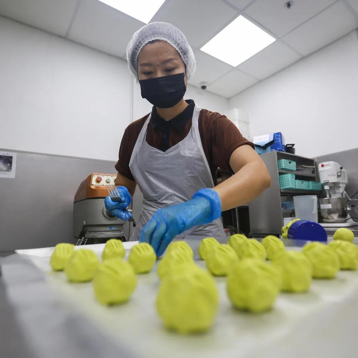HarriAnns Nonya Table central kitchen staff making moulding kueh bugis in JTC Bedok Food City.