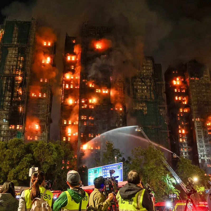 Firefighters tackle a fire engulfing residential buildings at Wang Fuk Court in the Tai Po district of Hong Kong, China, on Wednesday, Nov. 26, 2025. A major fire has engulfed an eight-tower, high-rise complex in Hong Kong, killing at least 13 people. Photographer: Yik Yeung-man/Bloomberg