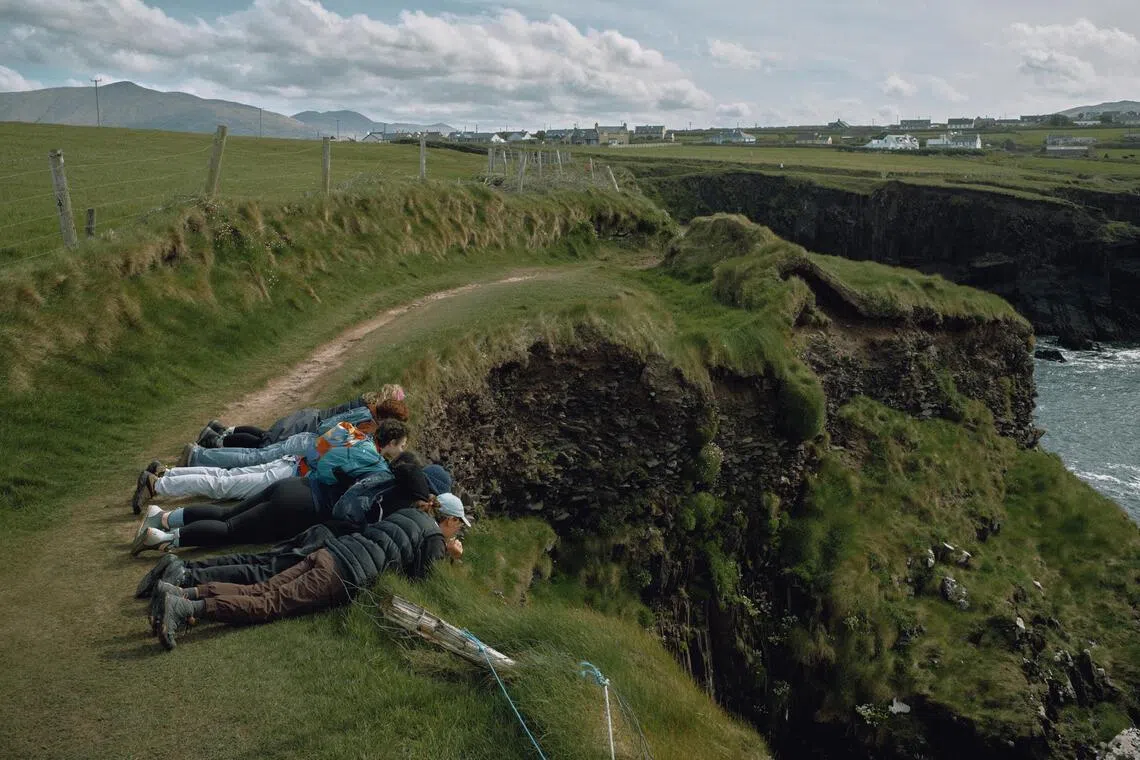 A group of friends peers down at the cliffs and sea in Dingle, Ireland on April 21.