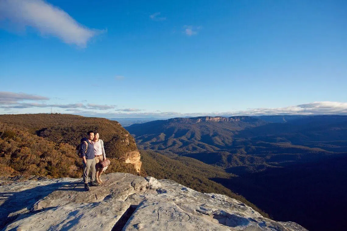 Asian couple on a sunrise stop at Lincoln Rock, the Blue Mountains