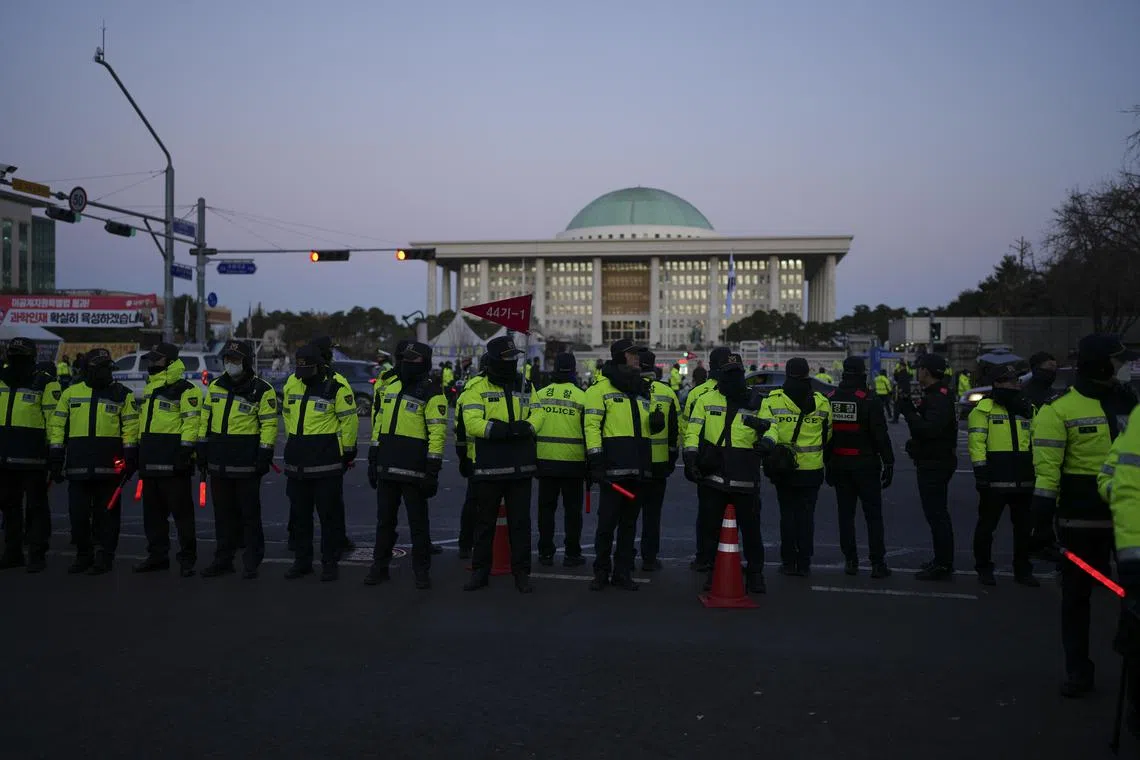 Police officers stand guard across the street from the main gate to the National Assembly building in Seoul, on Dec 4.