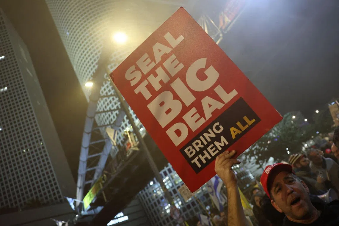 A demonstrator raises a placard during a protest calling for the release of hostages held captive in Gaza, in front of the Israeli Defence Ministry in Tel Aviv on Feb 8, 2025.