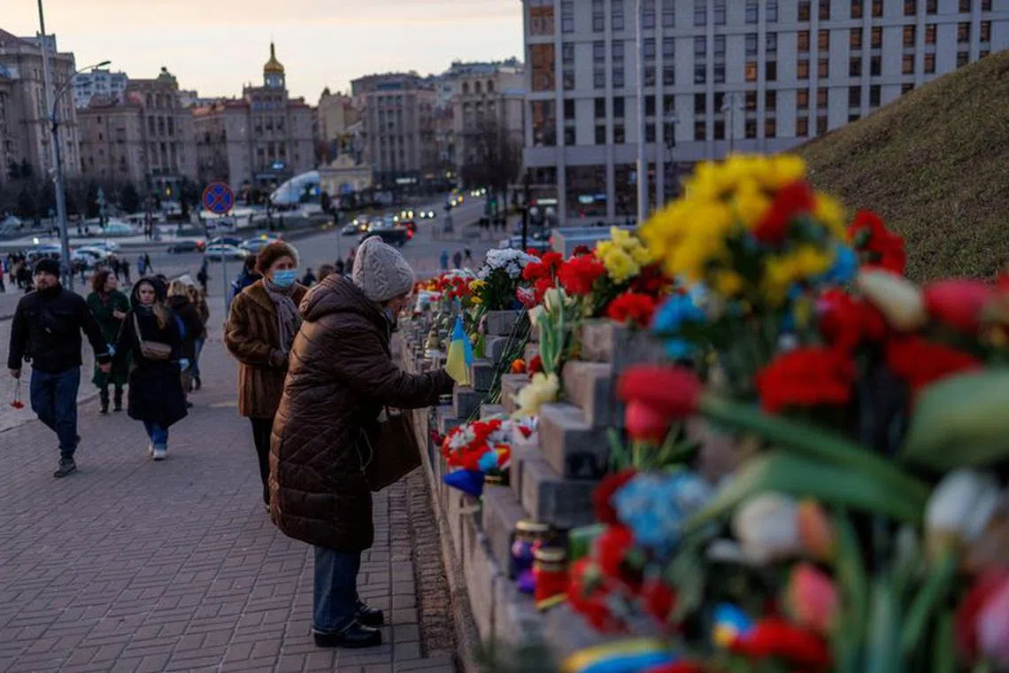FILE PHOTO: A woman pays her respects near the monument to the so-called \"Heavenly Hundred\", people killed in mass protests that toppled President Viktor Yanukovich in 2014, in central Kyiv, Ukraine February 20, 2022. REUTERS/Antonio Bronic/File Photo
