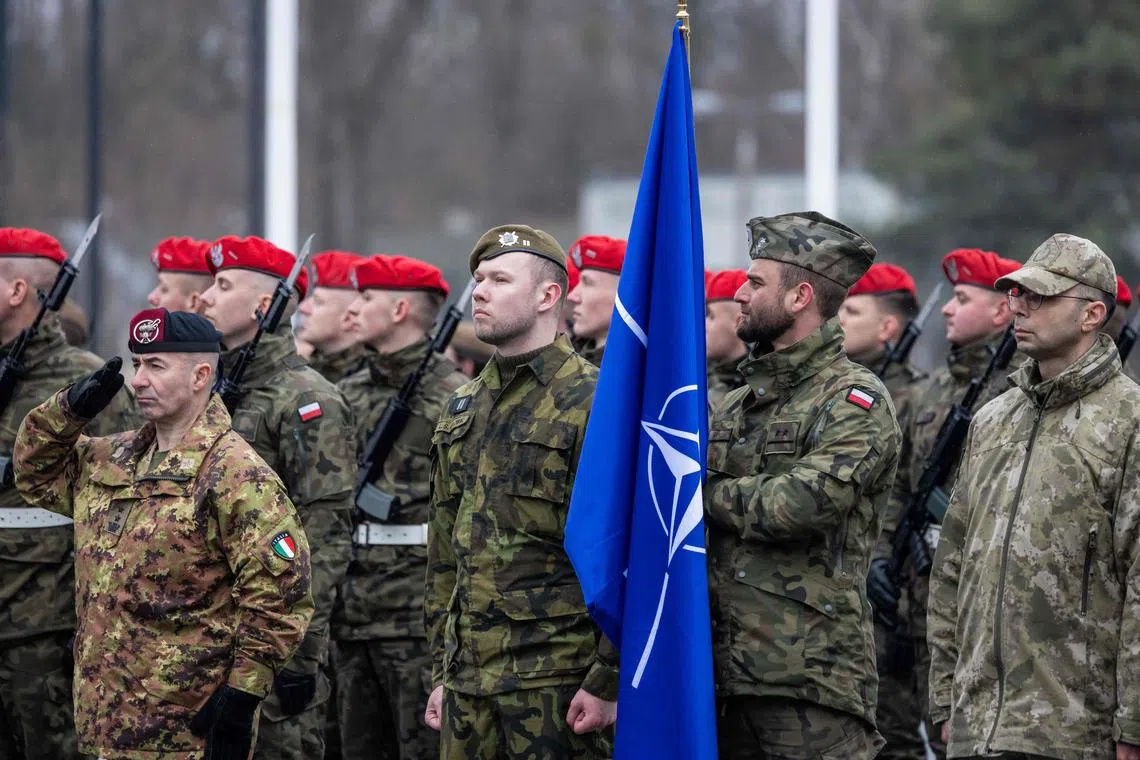 A Polish soldier holding a Nato flag as he takes part in a ceremony marking the 25th anniversary of Poland joining the Western defence alliance, on March 12, 2024.