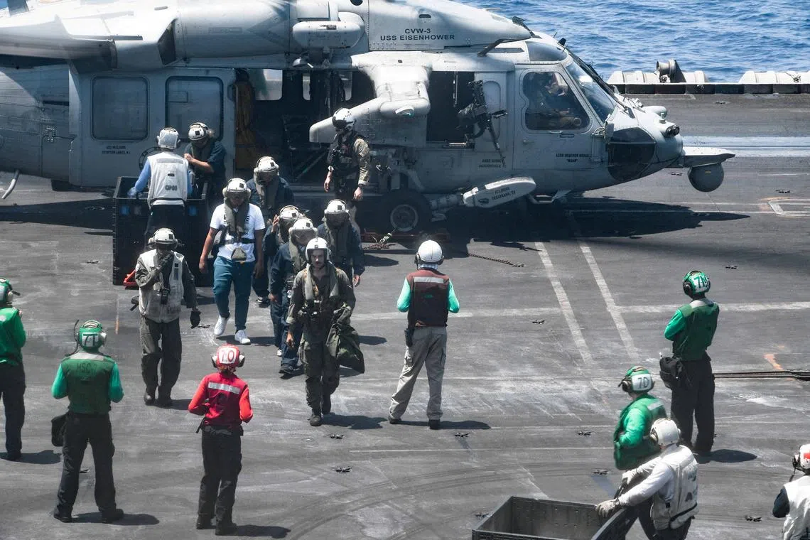 FILE PHOTO: Sailors from the Dwight D. Eisenhower Carrier Strike Group assist distressed mariners rescued from the Liberian-flagged, Greek-owned bulk carrier M/V Tutor that was attacked by Houthis, in the Red Sea, June 15, 2024.  U.S. Naval Forces Central Command/U.S. 5th Fleet/Handout via REUTERS/ File Photo