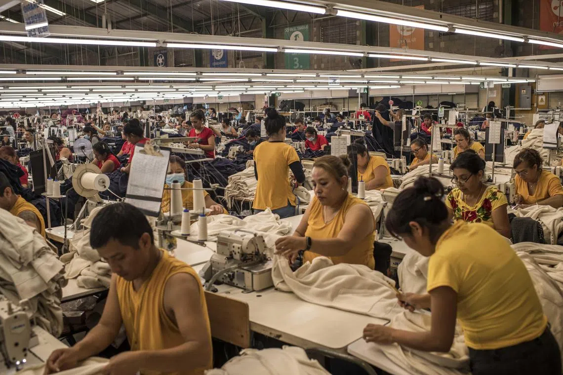Workers on the factory floor at Zuntex Apparel, where modest quantities of Columbia Sportswear’s hooded sweatshirts and button-down fishing shirts are now made, in Guatemala City, Oct. 3, 2023. Columbia Sportswear is shifting some production from China to Central America, looking for — as many international companies are now doing — ways to reduce dependence on faraway factories and decrease disruptions caused by shifting geopolitics. (Daniele Volpe/The New York Times)