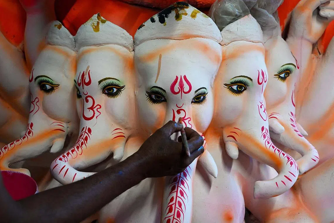 An artisan paints an eco-friendly idol of Hindu god Ganesha ahead of the Ganesh Chaturthi festival, at a workshop on the outskirts of Hyderabad in India on Sept 11.