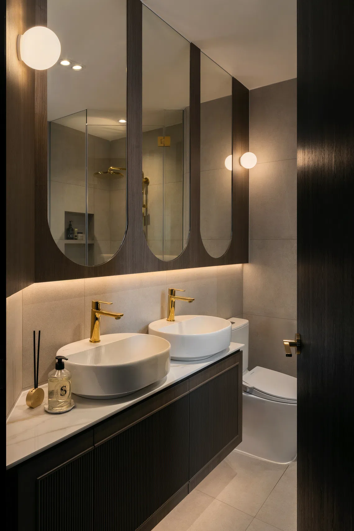 Brass-gold fittings and dark wood tones give the master bathroom a sophisticated touch.