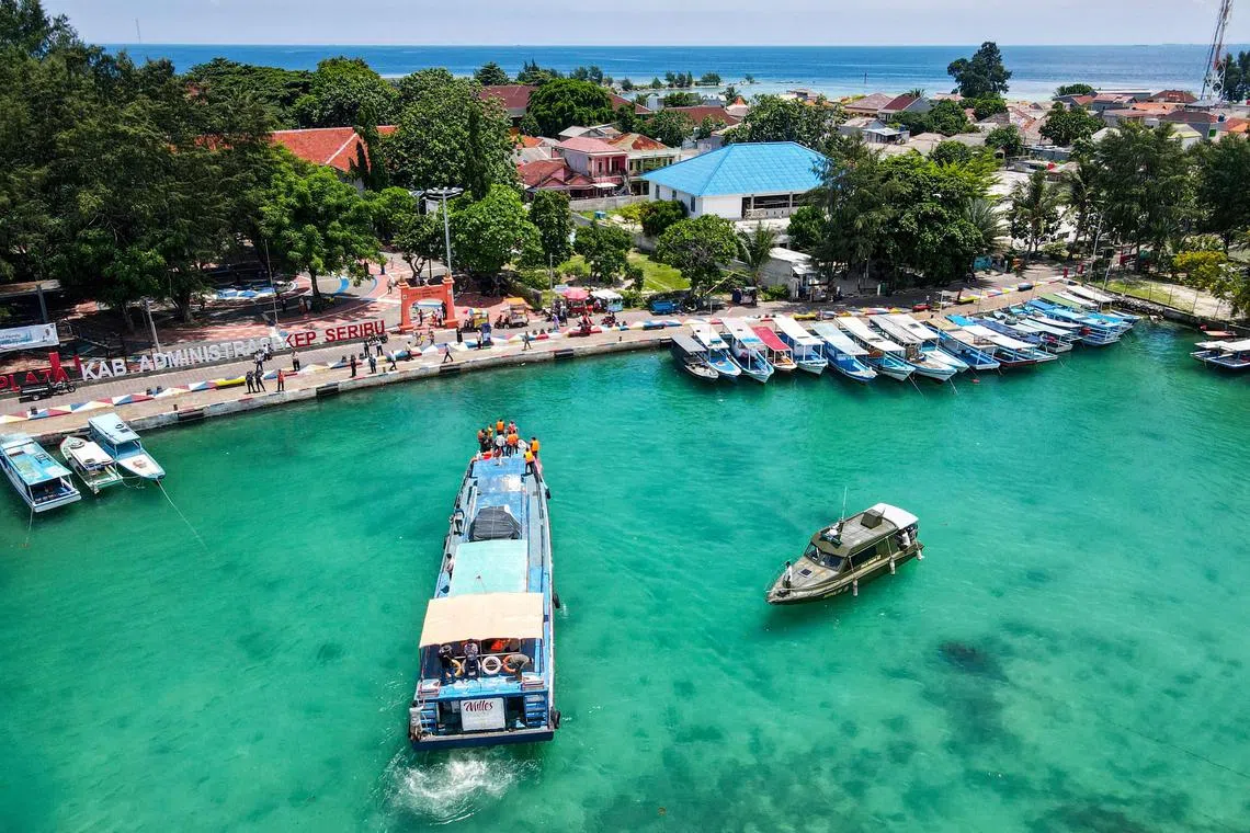 This aerial photo shows a motorboat carrying ballot boxes arriving at Pramuka Island of the Thousand Islands in Jakarta on February 9, 2024, ahead of Indonesia's presidential and legislative polls scheduled to be held on February 14. (Photo by BAY ISMOYO / AFP)
