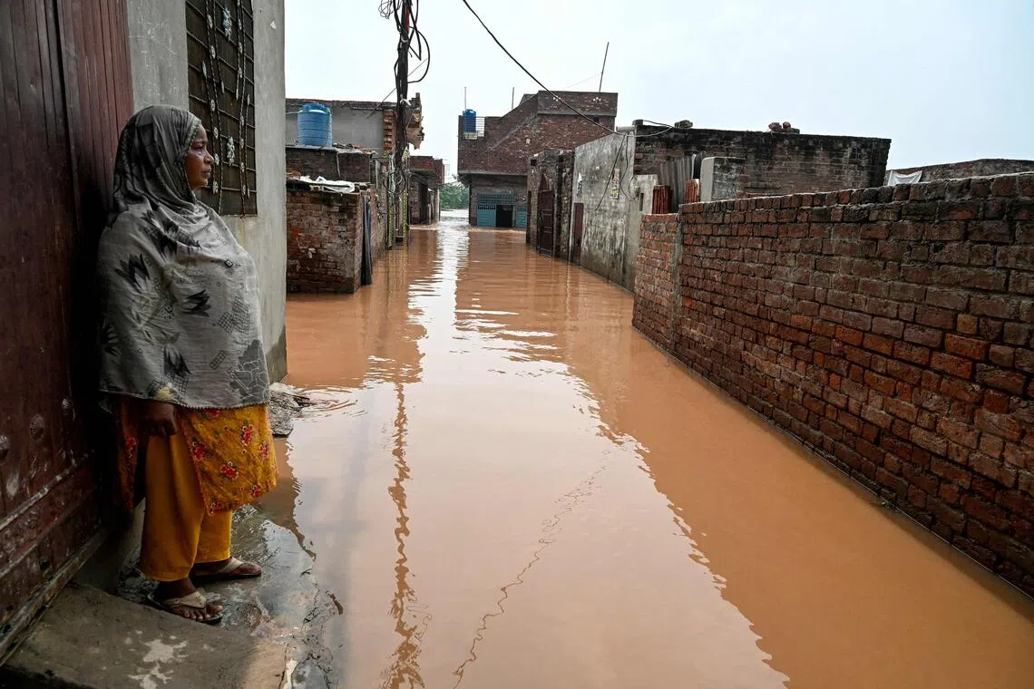 Ghulam Bano stands near her submerged home, after floodwaters entered from the overflowing Ravi river in Shahdara, Lahore on August 29, 2025. PHOTO: AFP