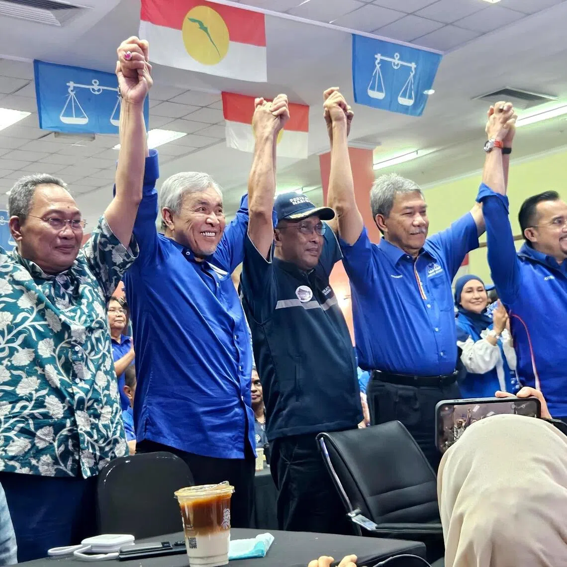PN secretary-general Takiyuddin Hassan (middle) flanked by BN president Ahmad Zahid Hamidi (left) and BN Negeri Sembilan chairman Mohamad Hasan (right) cheering the results in their favour in the Aug 1 state election at UMNO Negeri Sembilan headquarters in Seremban.