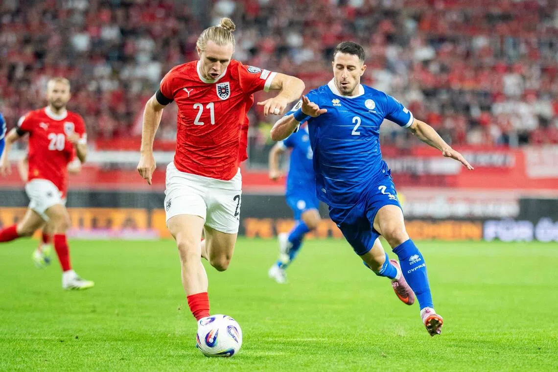Austria's midfielder Patrick Wimmer and Cyprus' defender Kostas Pileas during a World Cup qualifier.