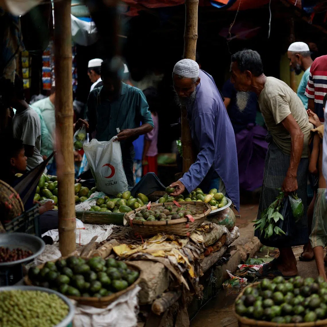 Rohingya refugees purchase vegetables from a kitchen market at a refugee camp in Cox's Bazar, Bangladesh.