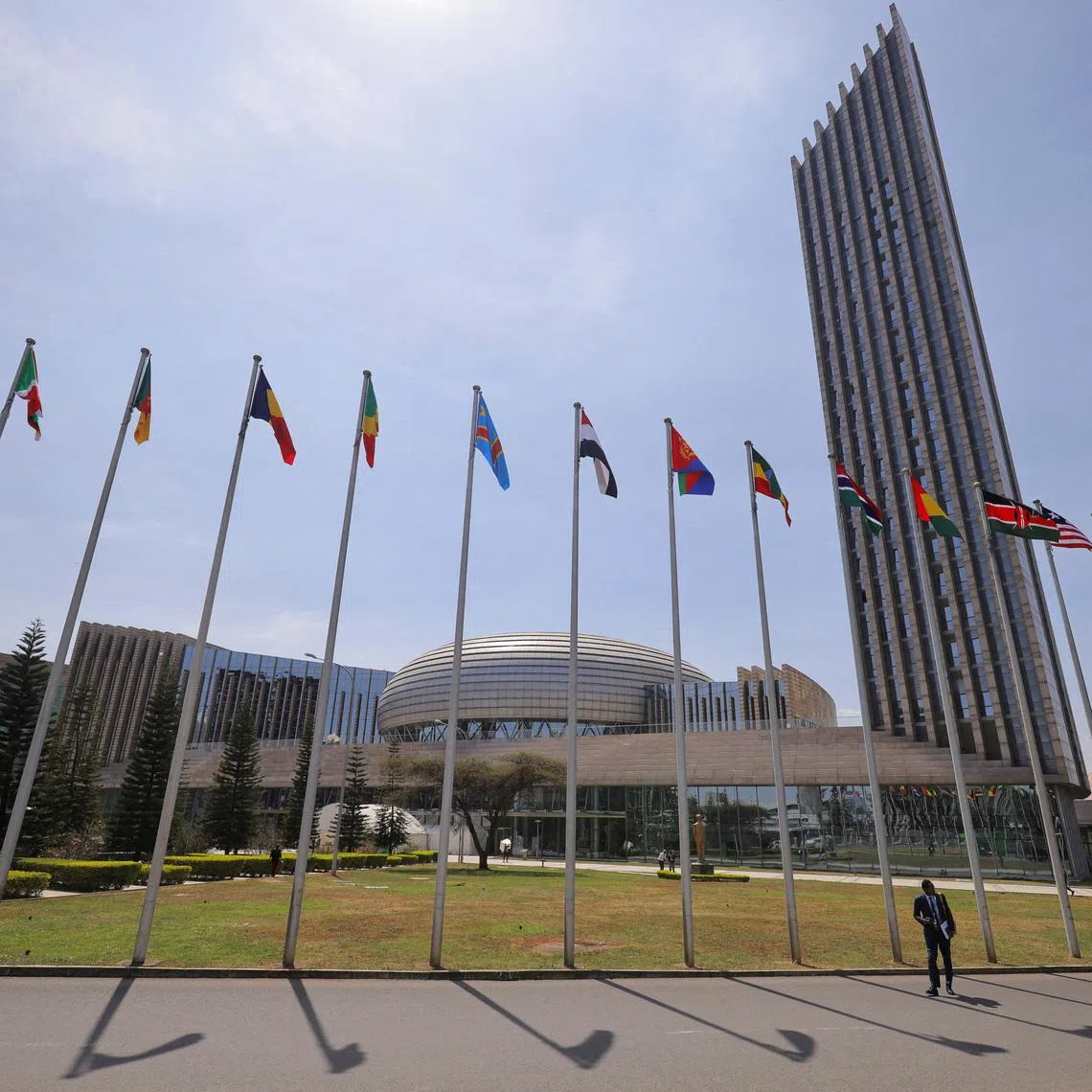 FILE PHOTO: A delegate walks next to African Union (AU) member states flags ahead of the 38th Ordinary Session of the Heads of State and Government of the African Union at the African Union Commission (AUC) headquarters in Addis Ababa, Ethiopia, February 14, 2025. REUTERS/ Tiksa Negeri/File Photo