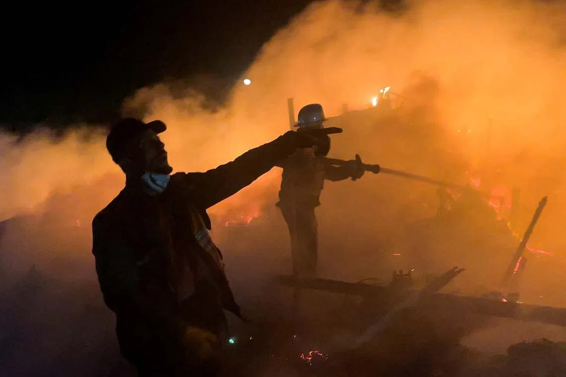 Palestinians trying to extinguish the flames after an Israeli airstrike on tents sheltering displaced people, in Khan Younis, in the southern Gaza Strip April 17, 2025. 