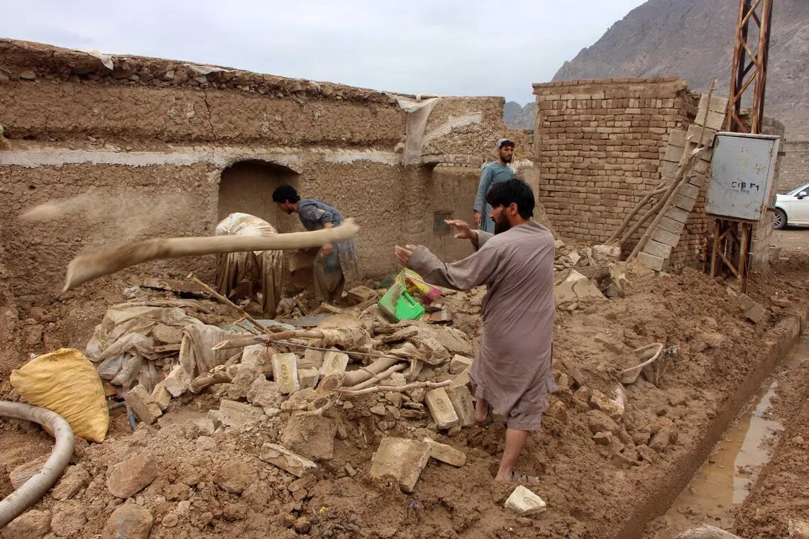 People check the damage on April 2 caused by heavy rains in Kandahar, Afghanistan.