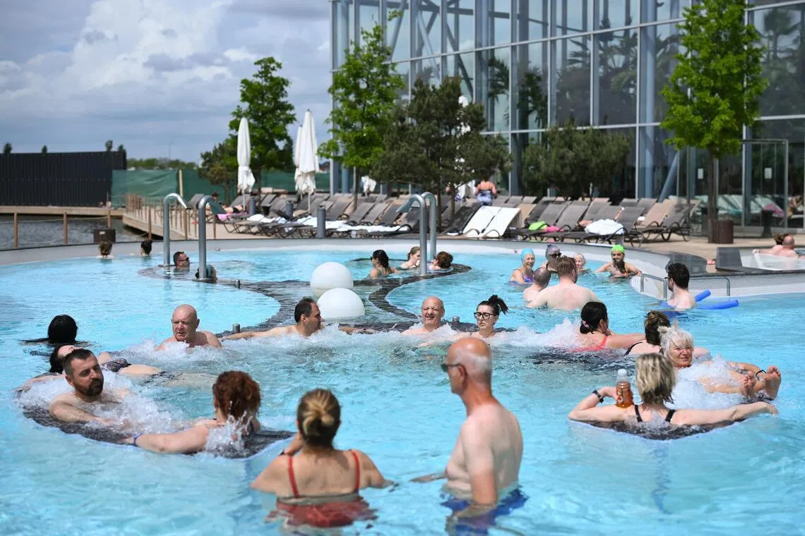 Visitors relaxing in the facility’s outdoor pool amid a Romanian spring breeze.