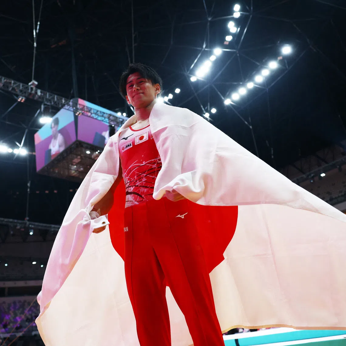 Artistic Gymnastics - 2025 World Artistic Gymnastics Championships - Mens Artistic Gymnastics - All-Around Final - Indonesia Arena, Jakarta, Indonesia - October 22, 2025 Japan's Daiki Hashimoto celebrates with the Japan flag after winning the All-Around Final REUTERS/Issei Kato