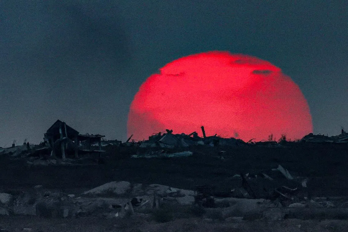 The sun setting behind destroyed buildings in the embattled territory, on Aug 27, 2025, amid the ongoing war between Israel and the Palestinian militant group Hamas. A spokesman for the Israeli military said Wednesday the evacuation of Gaza City was "inevitable" as the army prepares to conquer the Palestinian territory's largest city.