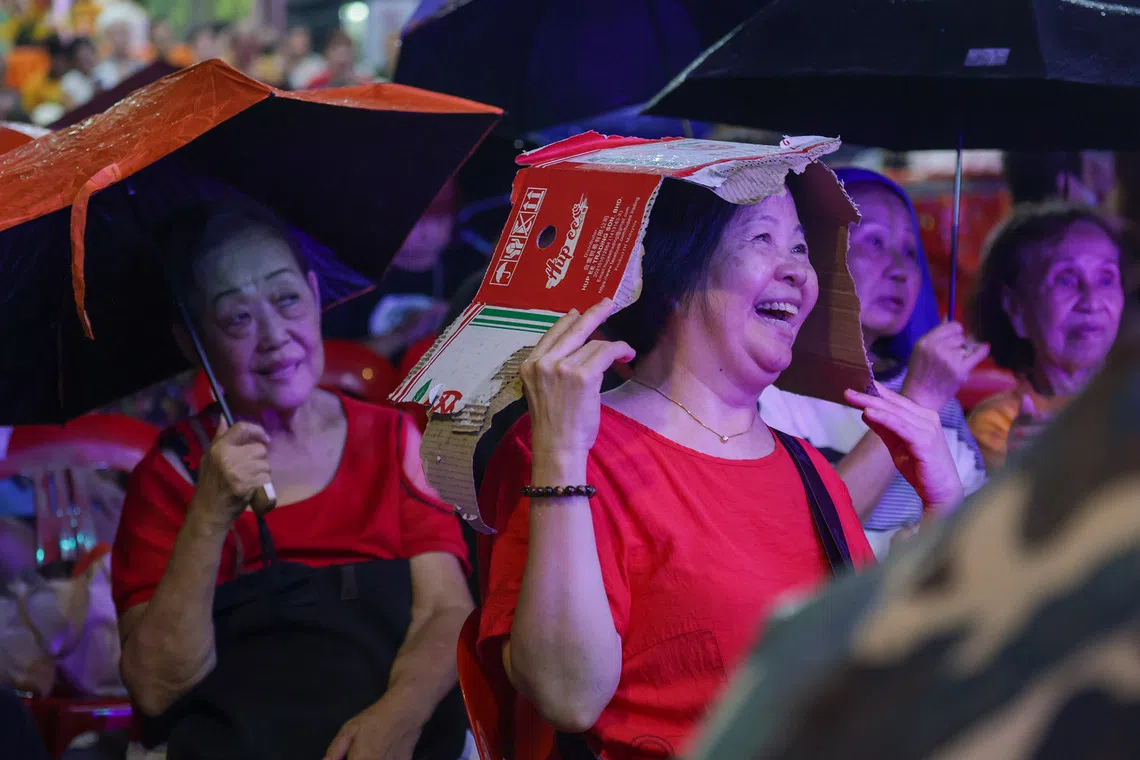 ST20260816_202670800792/Jasel Poh/sfghost/

An attendee enjoying the getai performance while shielding herself from the sudden downpour with a piece of cardboard on Aug 16, 2026.