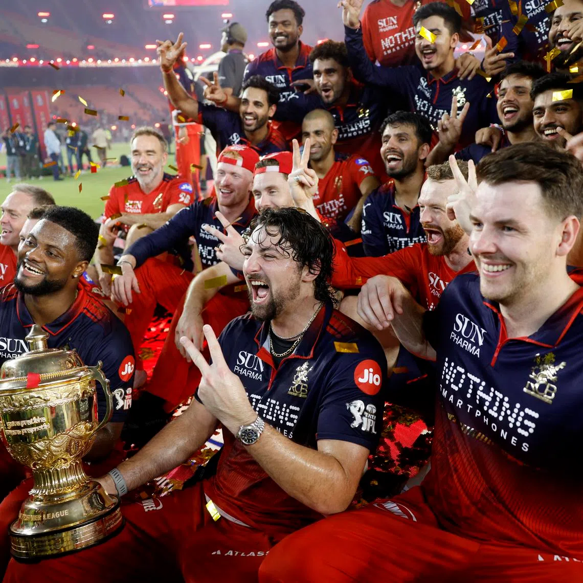 Cricket - Indian Premier League - IPL - Final - Royal Challengers Bengaluru v Gujarat Titans - Narendra Modi Stadium, Ahmedabad, India - May 31, 2026 Royal Challengers Bengaluru's Tim David lifts the trophy as he celebrates with teammates after winning the Indian Premier League REUTERS/Amit Dave