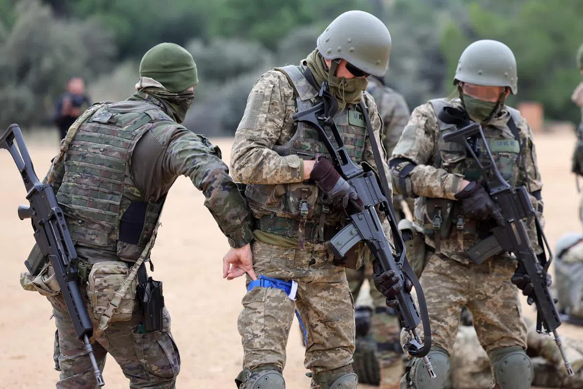 A Spanish military instructor (left) trains a group of Ukrainian soldiers, at the Spanish army base of Toledo, on Dec 2, 2022.