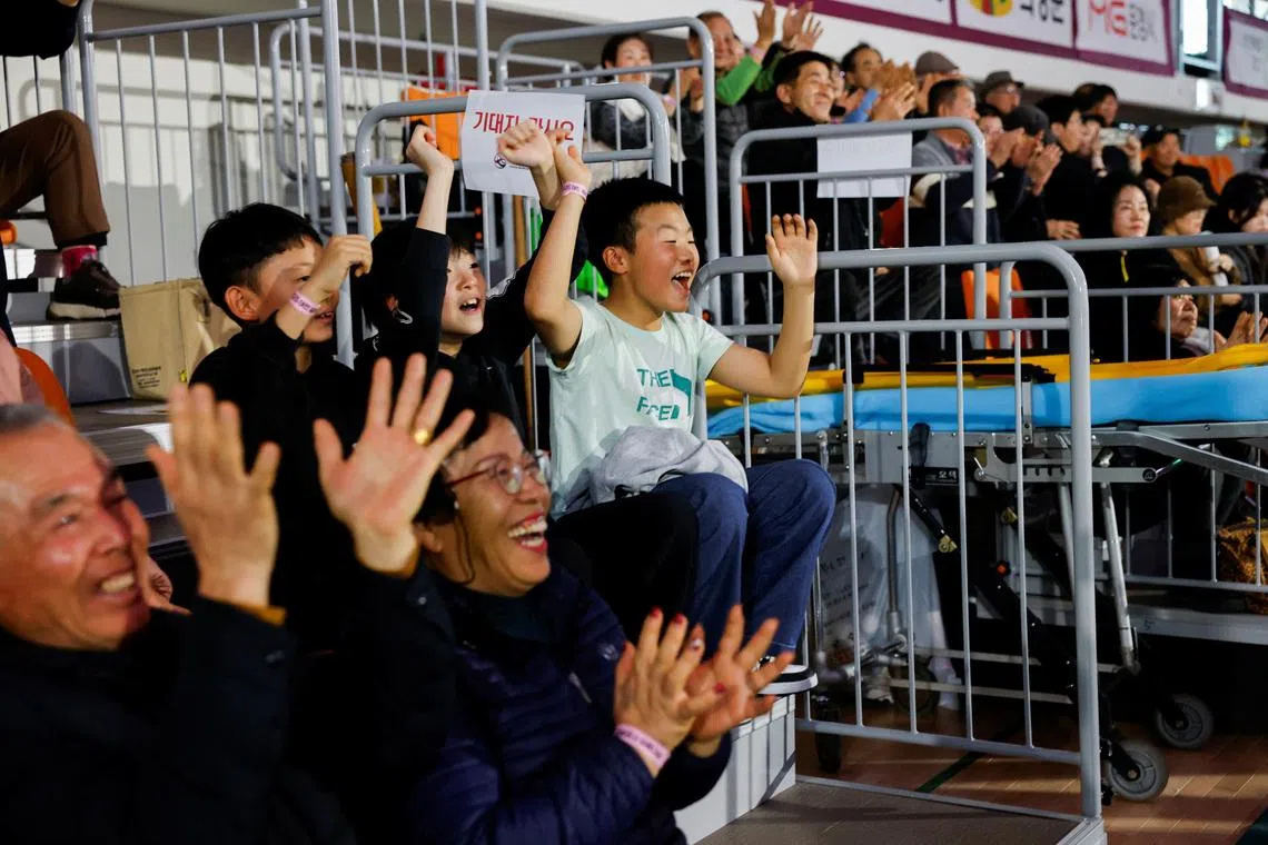 Spectators celebrate a ssireum wrestler’s victory after a Lunar New Year Ssireum championship final at the Taean Complex Indoor Gymnasium in Taean, South Korea, on Feb 15. 