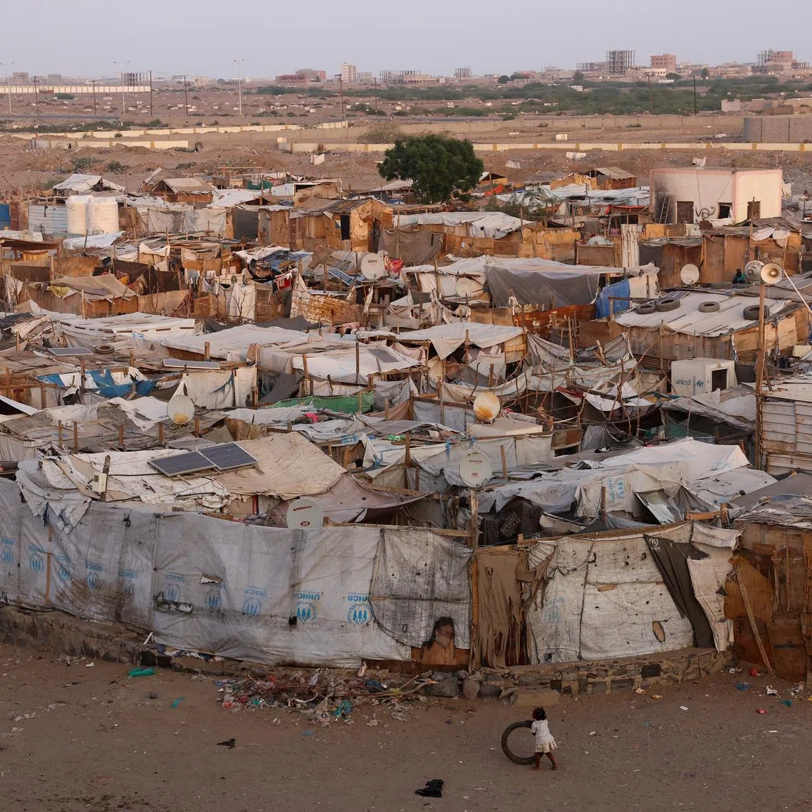 A girl plays with a tire next to a displaced persons camp in Aden, Yemen, October 19, 2024. REUTERS/Amr Alfiky