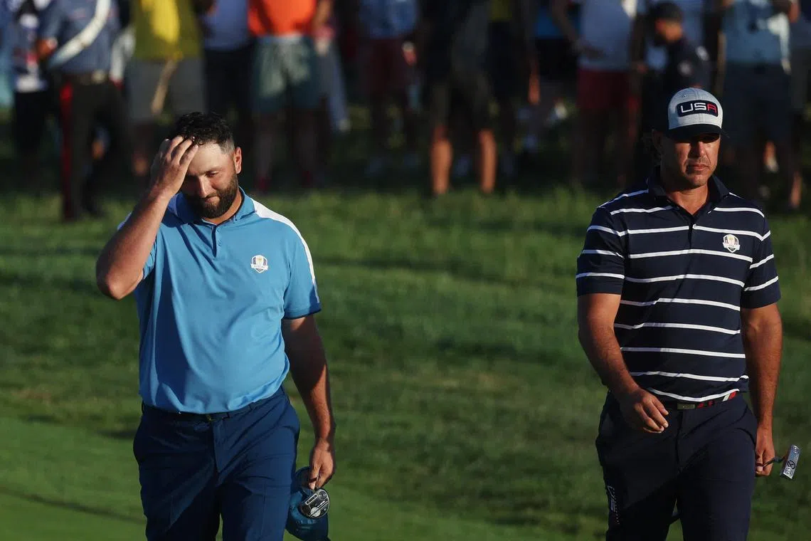 Team Europe's Jon Rahm with Team USA's Brooks Koepka on the 18th hole after the match is halved during the Four-Balls.
