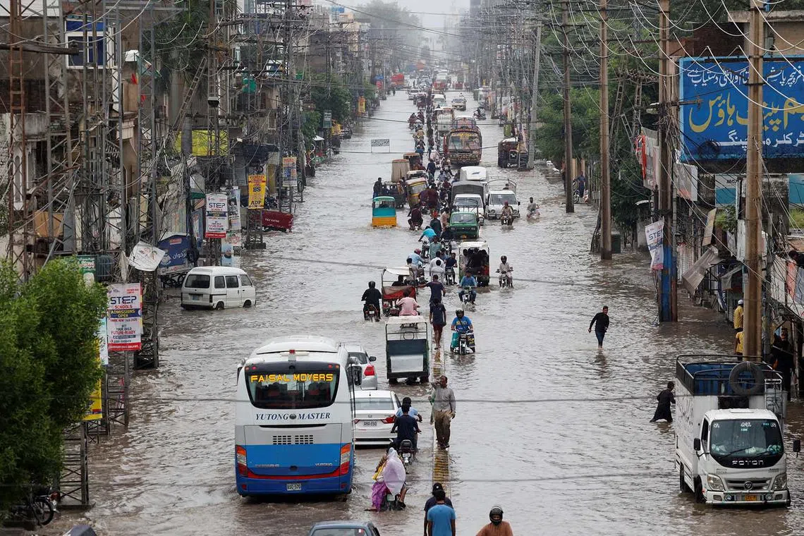 Vehicles moving along a flooded road following monsoon rain and rising water levels in Sialkot, Punjab province, Pakistan, Aug 27, 2025. 