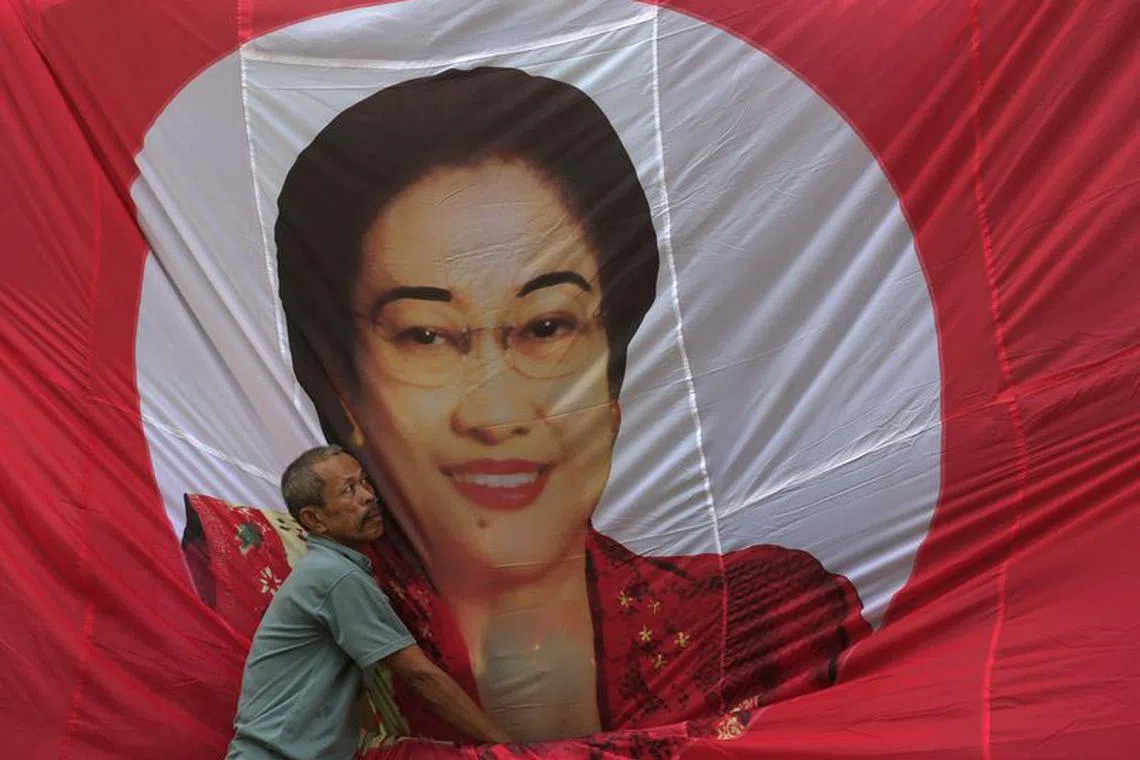 A man fixes a banner of Indonesia's former President Megawati Sukarnoputri, head of main opposition party Indonesian Democratic Party of Struggle (PDI-P), at Tanjung Priok slump area in Jakarta, February 28, 2014. REUTERS/Beawiharta/File Photo