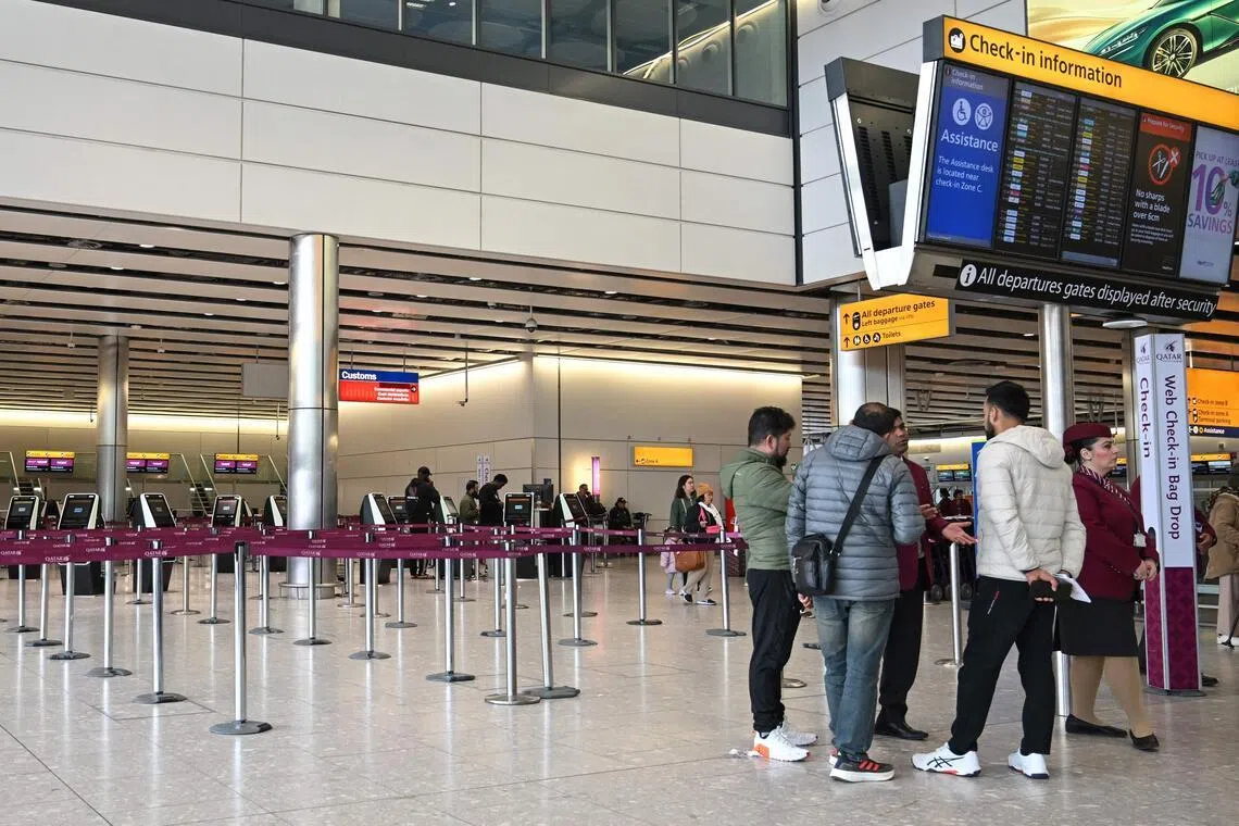 Staff from Qatar Airways helping people with questions at their check-in area at London Heathrow Airport in west London on March 1, 2026, as flights are severely disrupted following the US and Israel's strikes on Iran. The biggest disruption to global air transport since the Covid pandemic continued on March 1, with thousands of flights affected and busy Middle Eastern hubs including Dubai and Doha shuttered as Iran lashed out after US-Israeli strikes. 