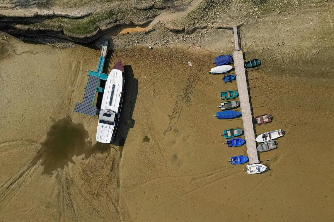 Dozens of boats are stranded high and dry on the cracked mud.