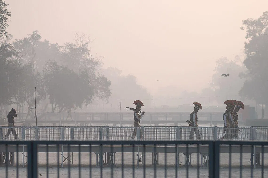 Indian Central Industrial Security Force (CISF) personnel walking across a bridge amid smoggy conditions in New Delhi, India on Jan 20, 2026. 