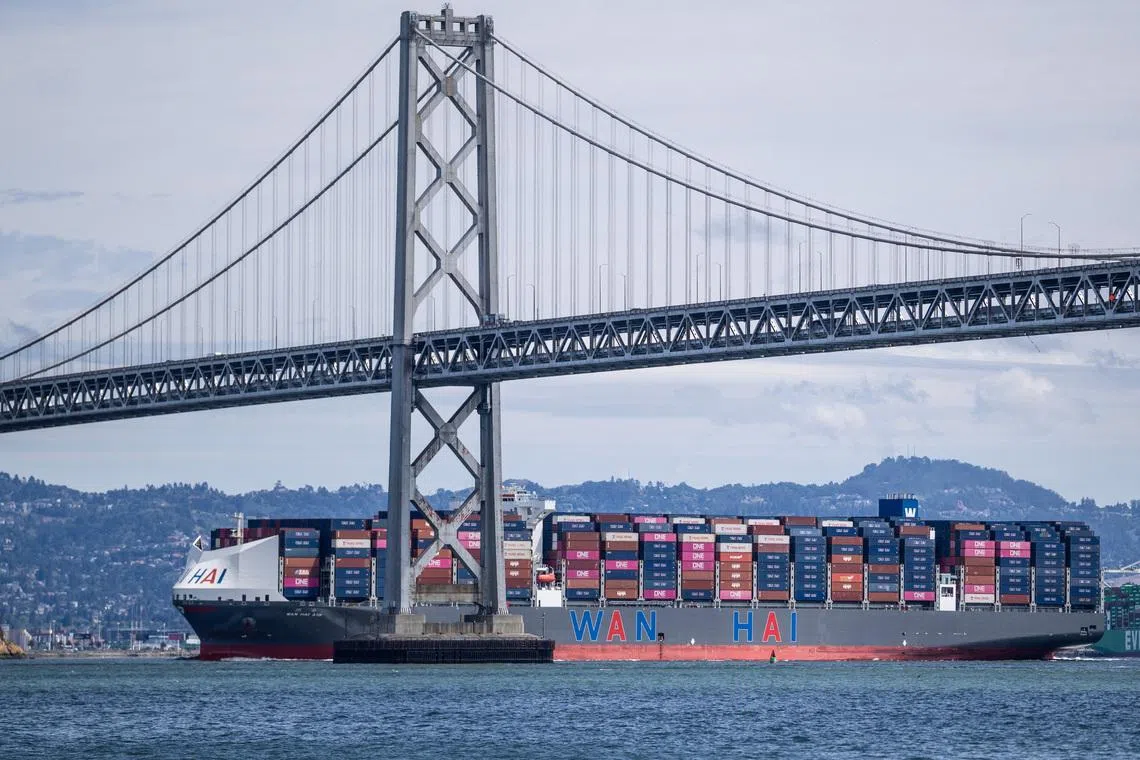 FILE PHOTO: A container ship passes under the San Francisco-Oakland Bay Bridge, in San Francisco, California, U.S., April 9, 2026. REUTERS/Carlos Barria/ File Photo