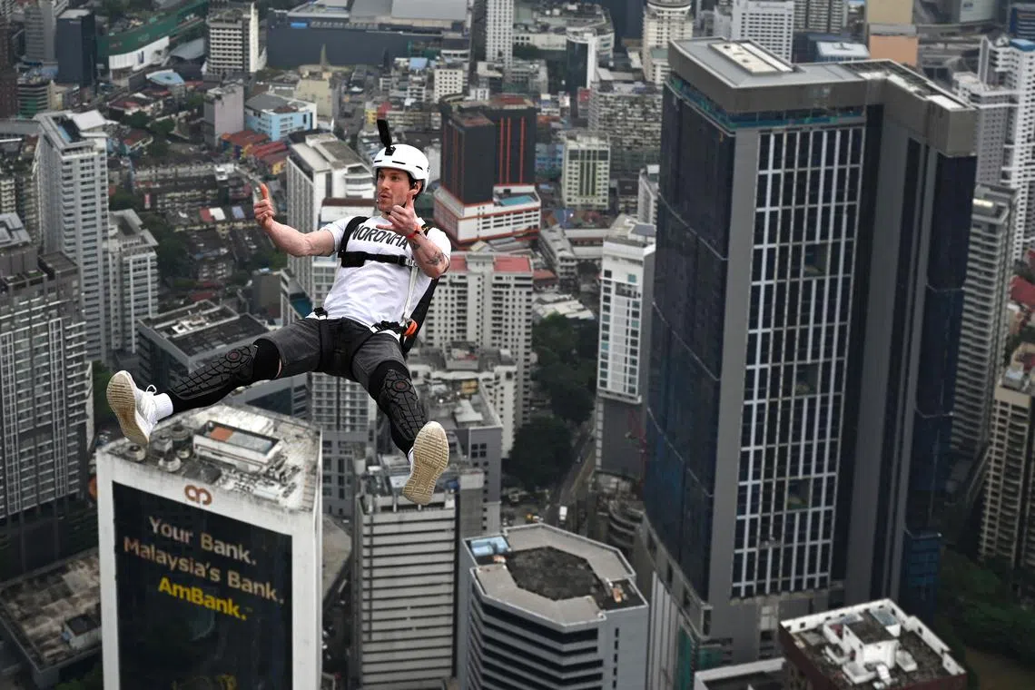 Base jumper Samuel Schumacher of Switzerland leaps from the 300-metre high open deck of Malaysia's landmark Kuala Lumpur Tower during the International Tower Jump in Kuala Lumpur on Feb 3, 2023.