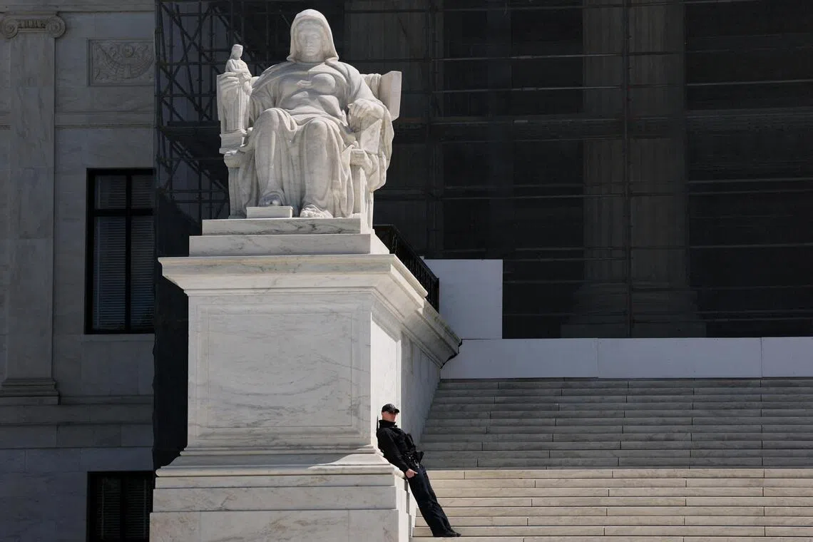 FILE PHOTO: A U.S. Supreme Court Police officer leans against the statue titled the Contemplation of Justice along the front steps of the U.S. Supreme Court building in Washington, D.C., U.S., April 8, 2025. REUTERS/Jonathan Ernst/File Photo