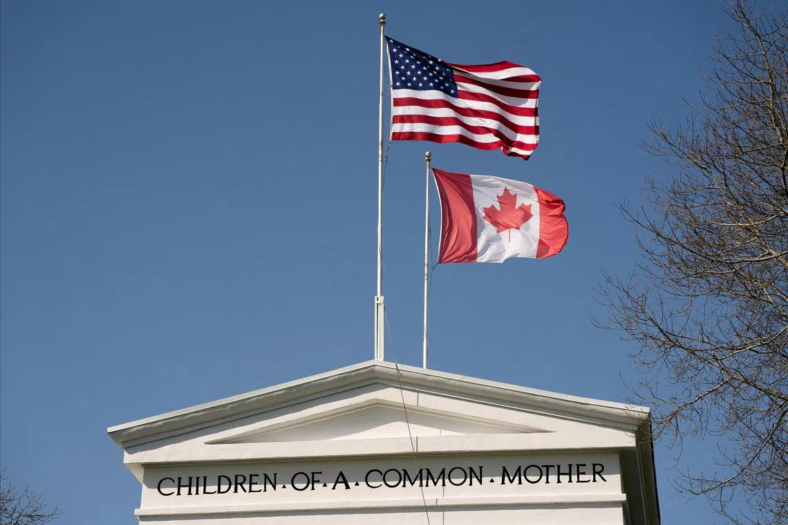 FILE PHOTO: Flags fly above the Peace Arch, at a Canada-U.S. border crossing known as the Peace Arch Border Crossing in Blaine, Washington, U.S. April 2, 2025.  REUTERS/David Ryder/File Photo