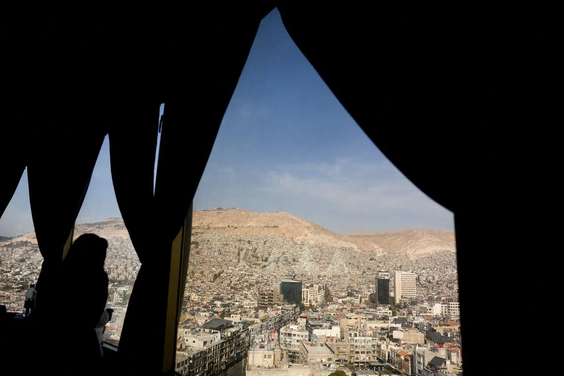 A woman and her daughter look at the view of buildings, after Syria's Bashar al-Assad was ousted, in Damascus, Syria, December 20, 2024. REUTERS/Amr Abdallah Dalsh