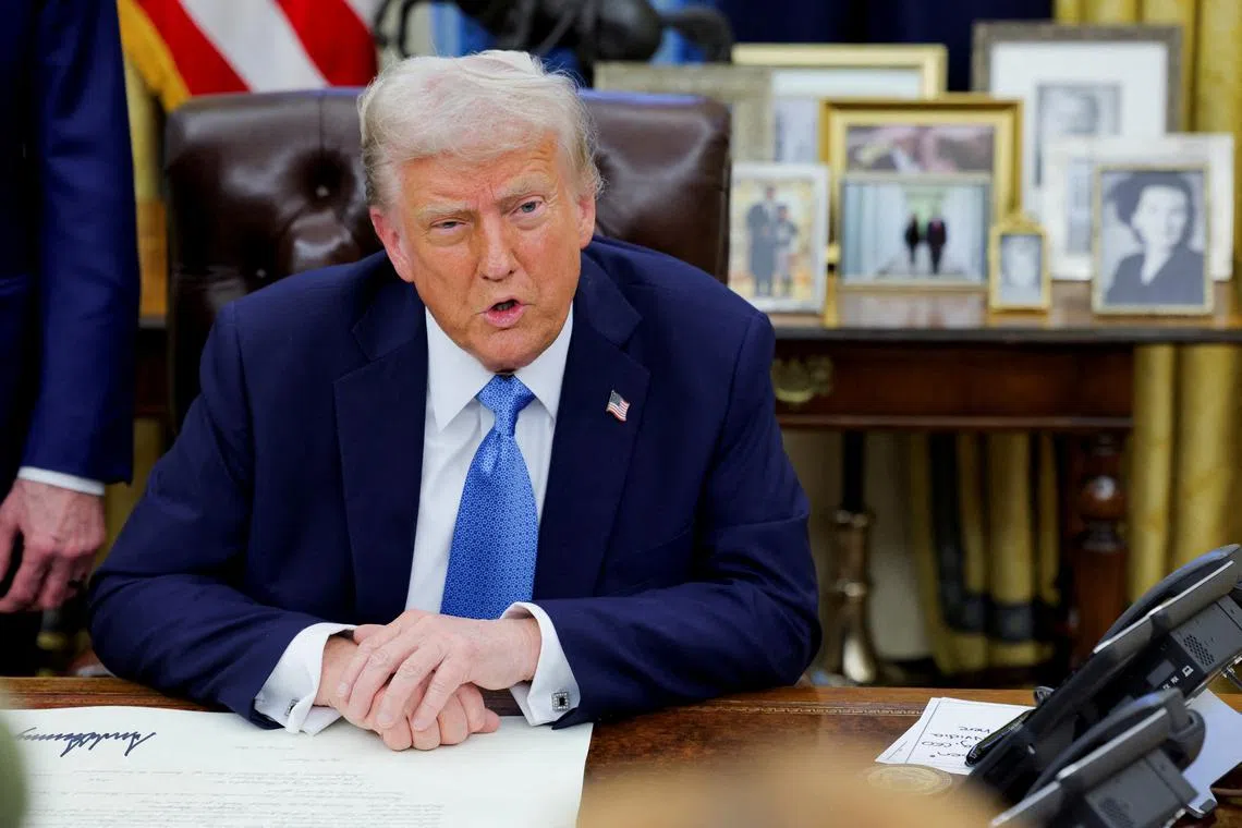 FILE PHOTO: U.S. President Donald Trump looks on as he signs an executive order in the Oval Office at the White House in Washington, U.S., January 31, 2025. REUTERS/Carlos Barria/File Photo