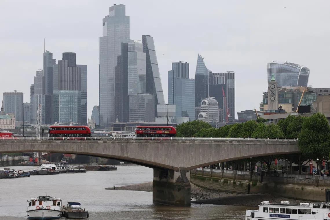 Buses cross Waterloo Bridge as skyscrapers in the City of London financial district are seen behind, in London, Britain, May 15, 2025. REUTERS/Toby Melville