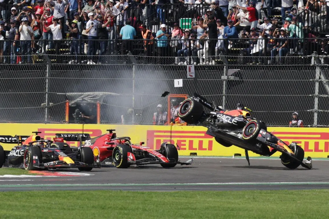 Red Bull's Sergio Perez crashes at the first corner of the race after contact with Ferrari's Charles Leclerc at Mexico City Grand Prix on October 29, 2023.